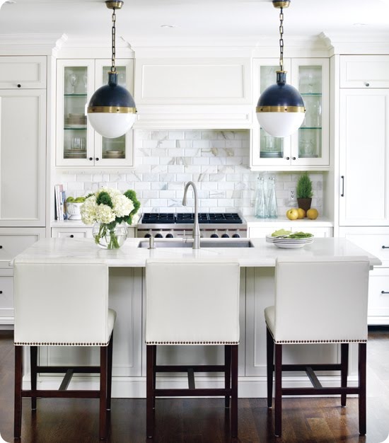 style at home kitchen white nailhead trim barstools cararra marble subway tile backsplash hick pendant lights blue gold crown molding top cabinets dark wood floors